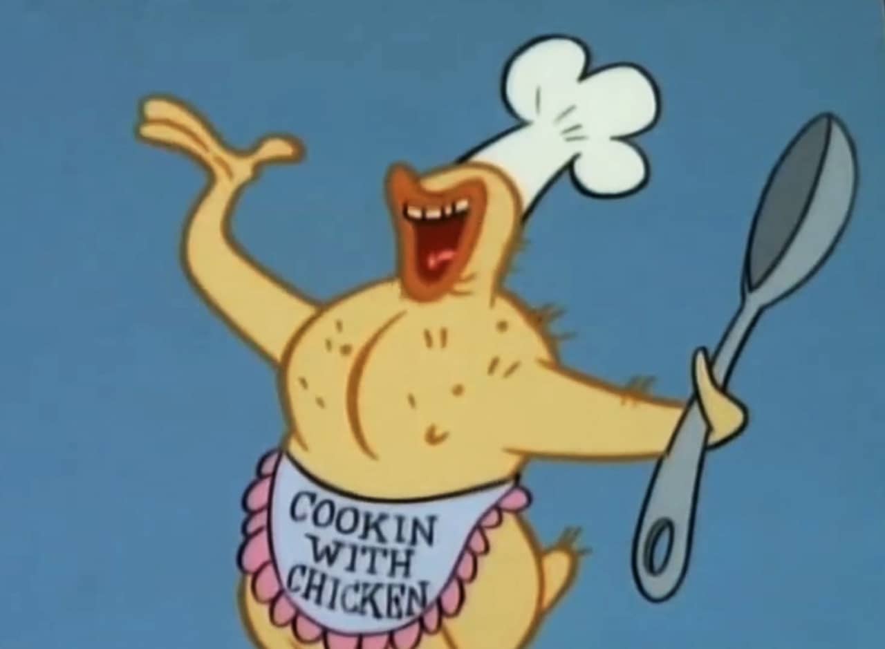 a defeathered chicken holding a big spoon and wearing a chef’s hat