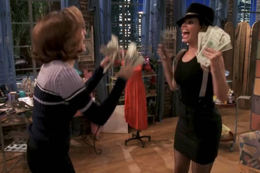 Cordelia and friend excitedly holding stacks of cash