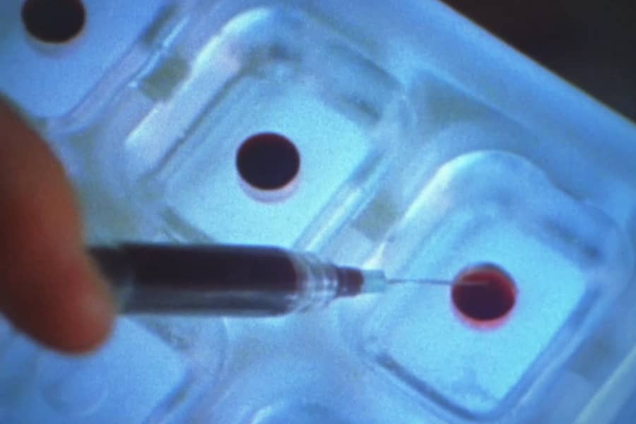 a syringe injects blood into a plastic mold