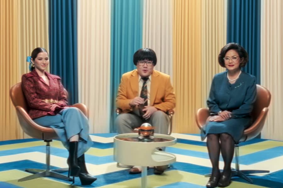 host with two women guests: a younger, stylish woman and an older more buttoned-up one