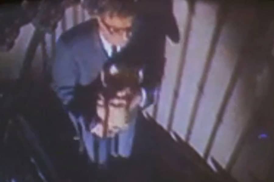 Michael Caine carries a bag upstairs