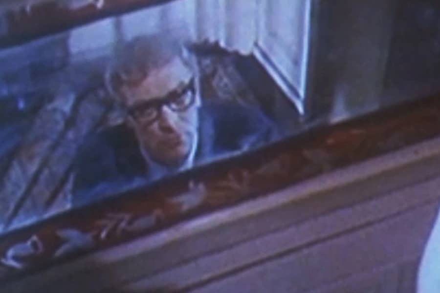 Caine looks up at a mirror in a hallway