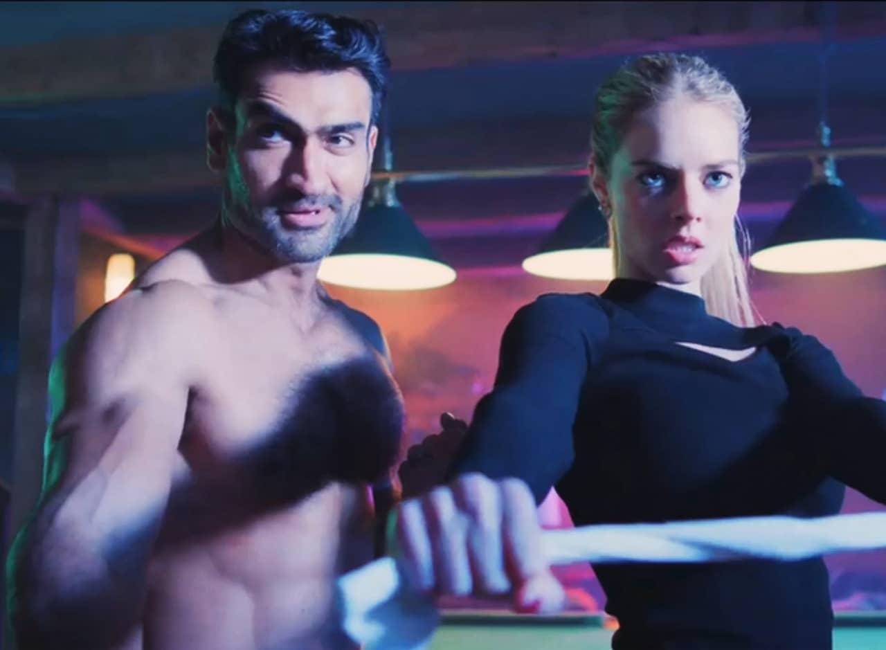 Kumail Nanjiani, shirtless, and Lisa Burton in fighting poses