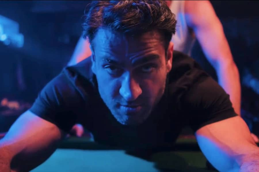 Kumail bent over a pool table