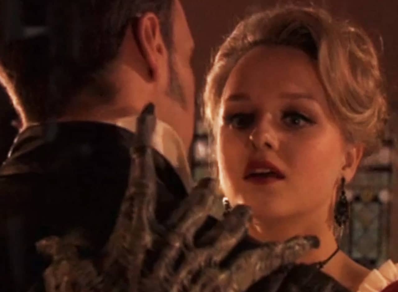 blonde woman sees a creepy hand on the back of her date