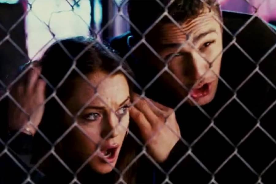 Lohan and James Franco behind a fence