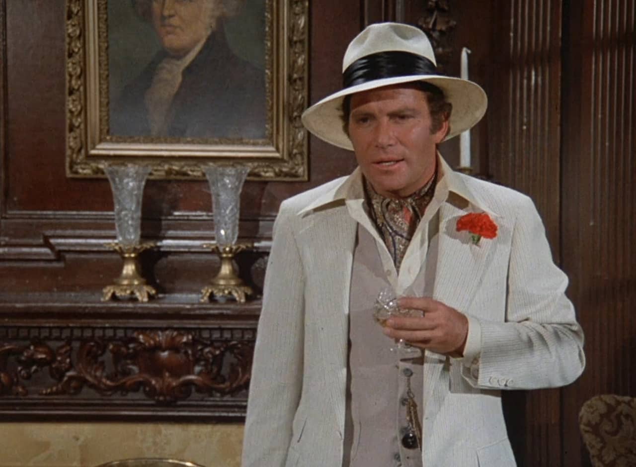 Detective Lucerne played by Ward Fowler wearing a white jacket and hat