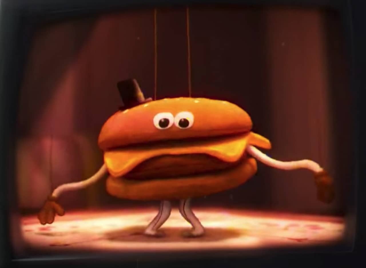 a felt burger puppet with googly eyes and top hat