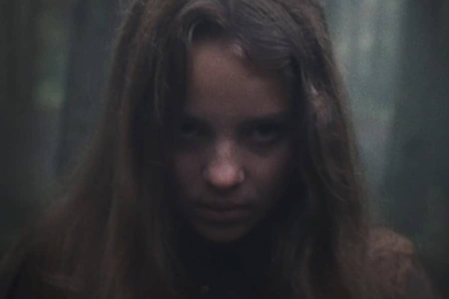 girl in the woods making a menacing face