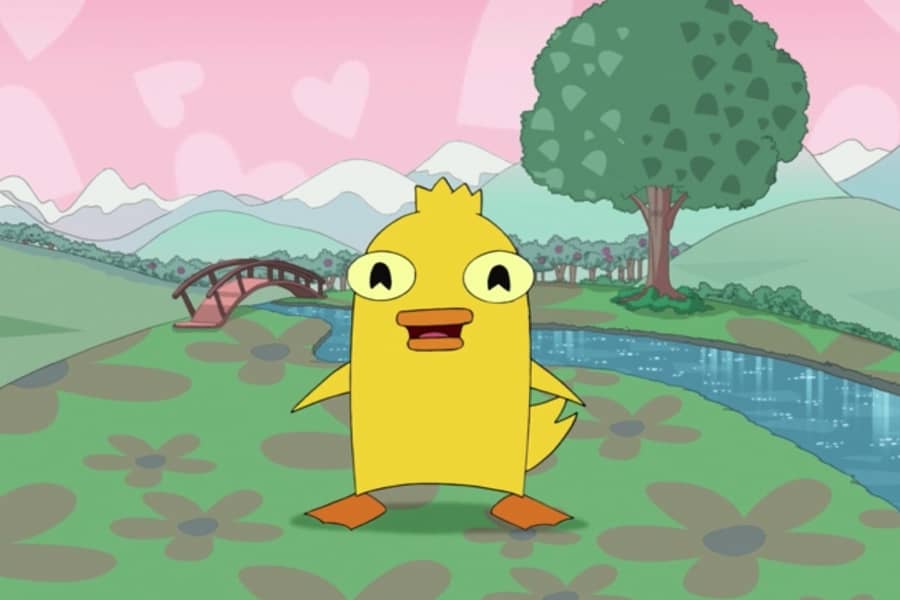 Ducky Momo standing in nature next to a stream