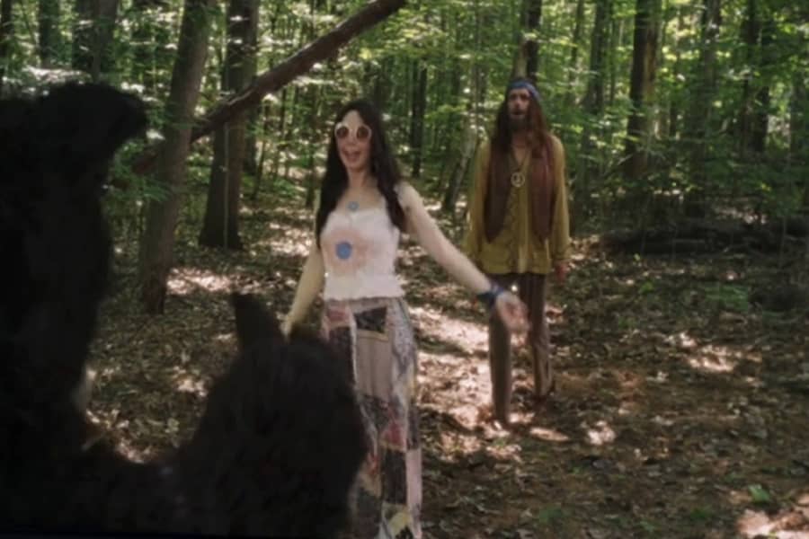 hippie woman running toward a bear