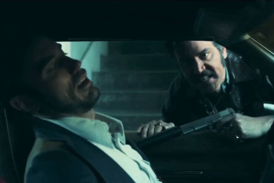 Lonny holding a gun on a guy from outside a car window
