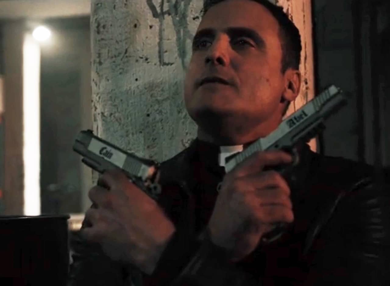 Father Rick Garvey wielding two guns