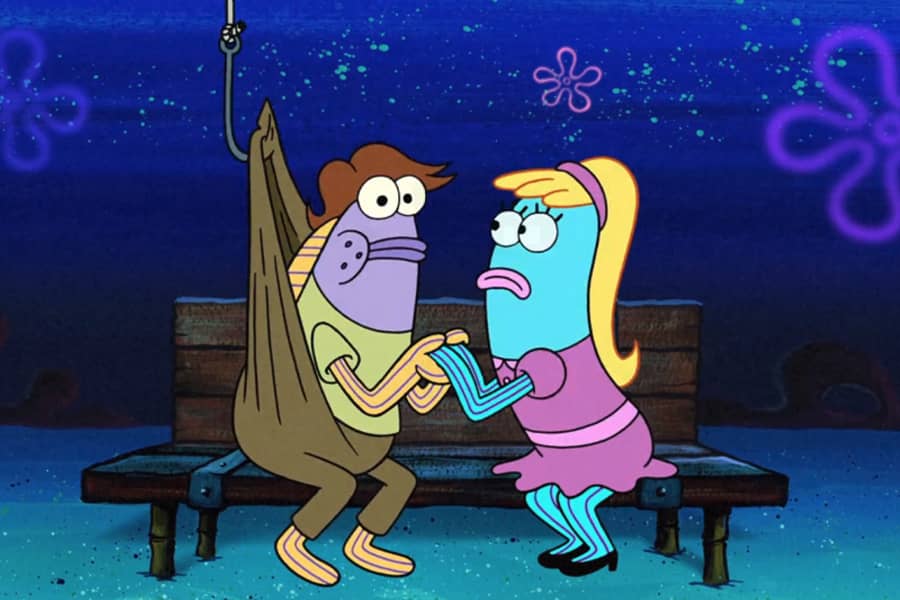 couple on a bench and the boy fish has a hook pulling his pants upward