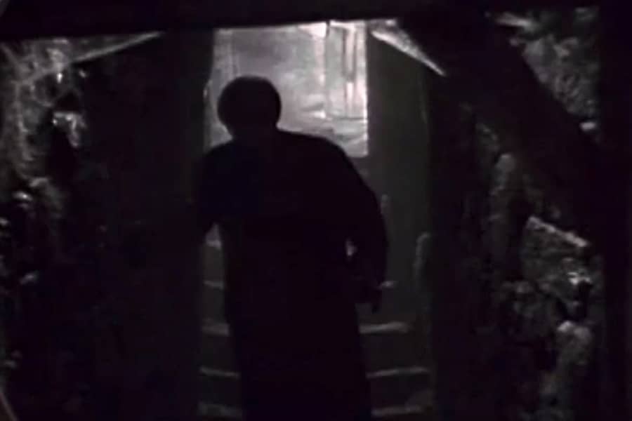 silhoutte of a man in a dark basement