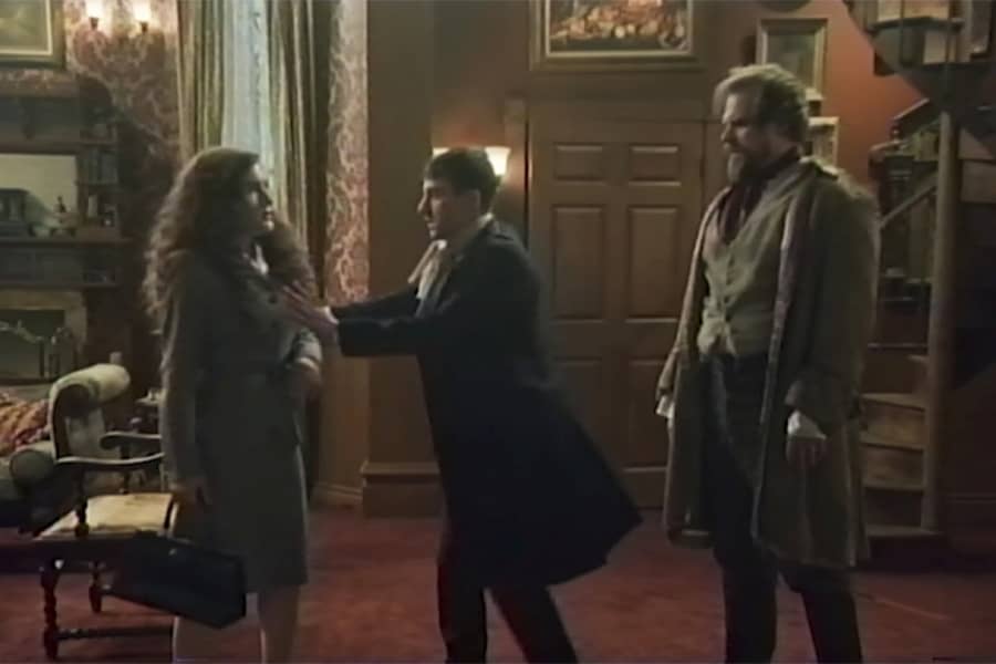 a young man shoos a woman away from Dr. Frankenstein