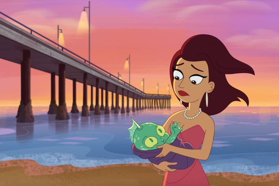 woman in pearls holding a sea creature baby by a pier