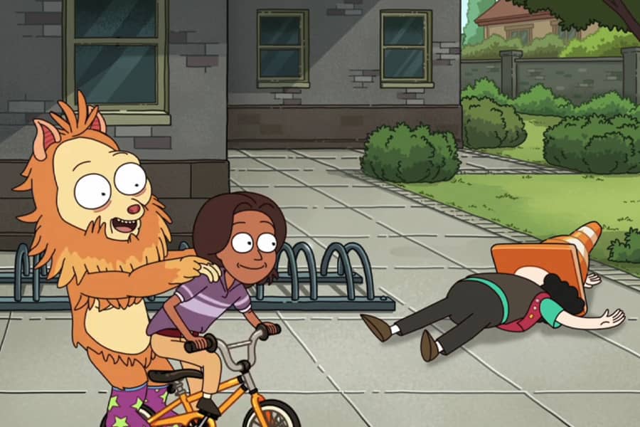 Funbucket and boy riding a bike next to an adult lying on the ground with a parking cone on their head