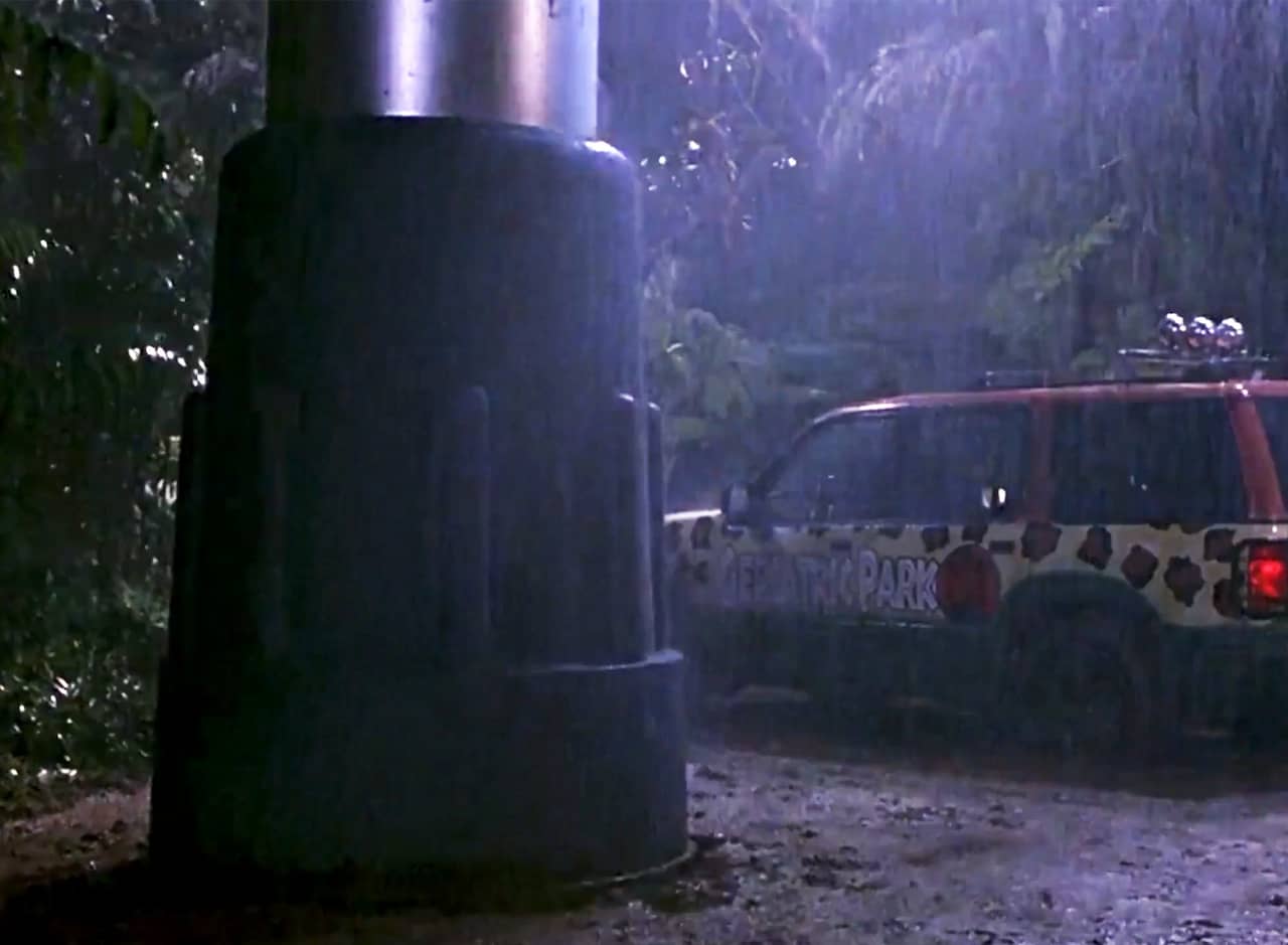 a giant rubber walker foot next to a theme park Jeep in the rain