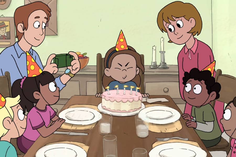 child blowing out candles on a birthday cake