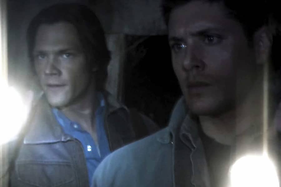 Sam and Dean Winchester hold flashlights
