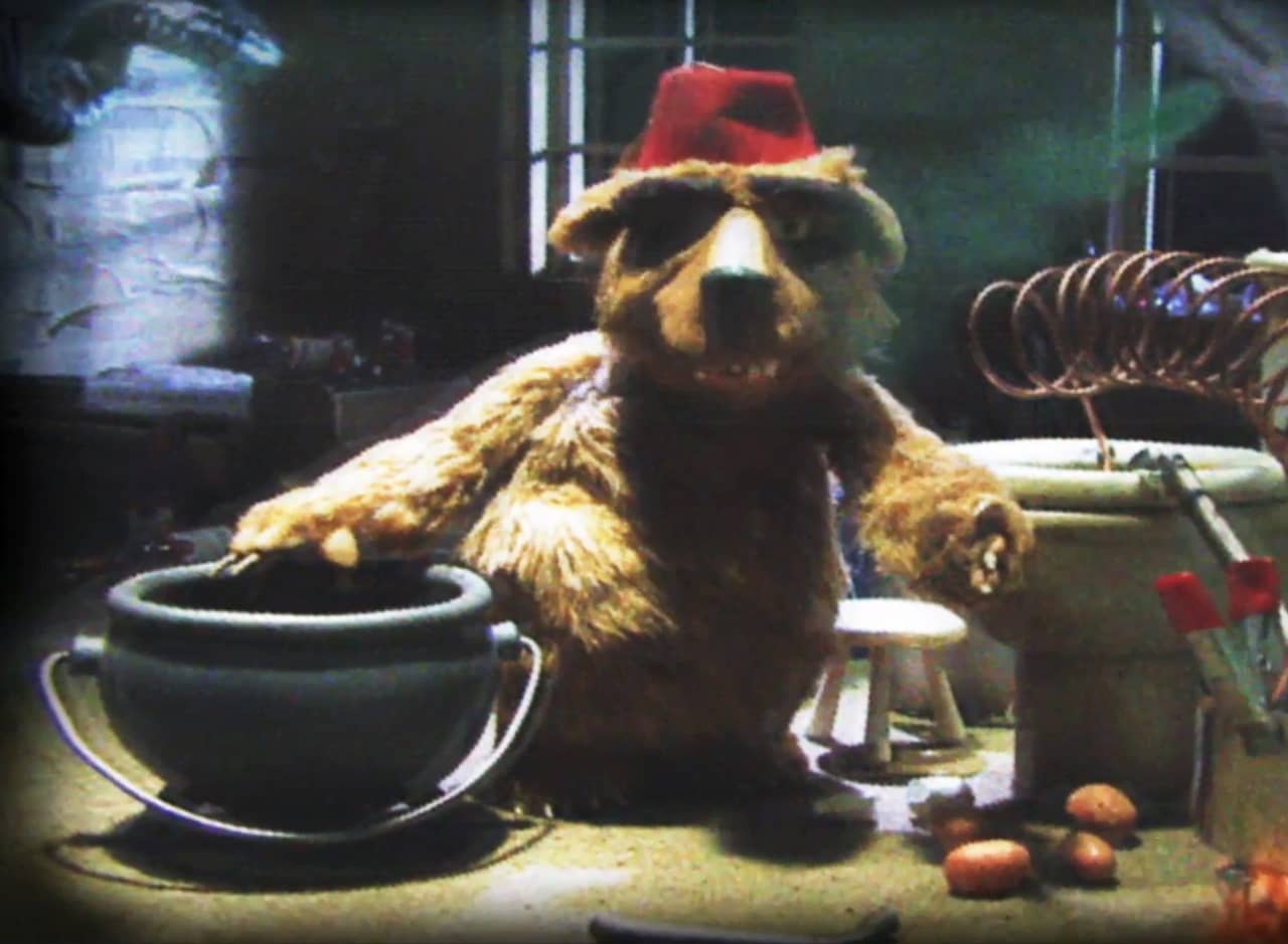 Morreski the bear in a makeshift lab with a cauldron