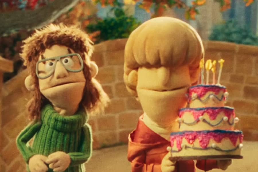 Bug and Mush who is holding a tiered birthday cake