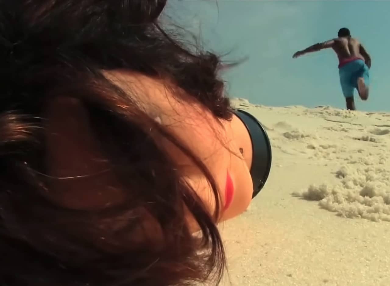 mannequin head on the beach as a man runs away in the distance