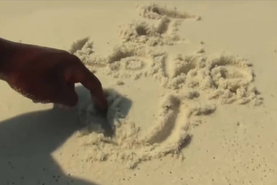 man writing “I love you” in the sand