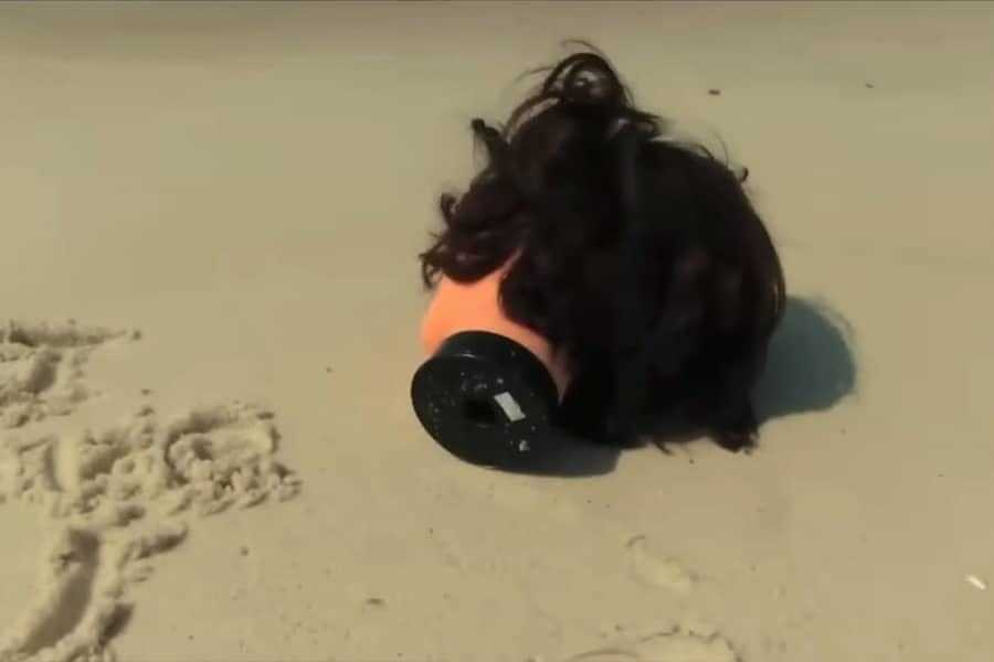 mannequin head on its side on the sand