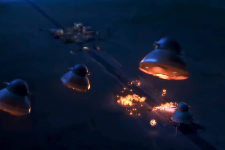 small alien ships in the sky with fire and explosions below