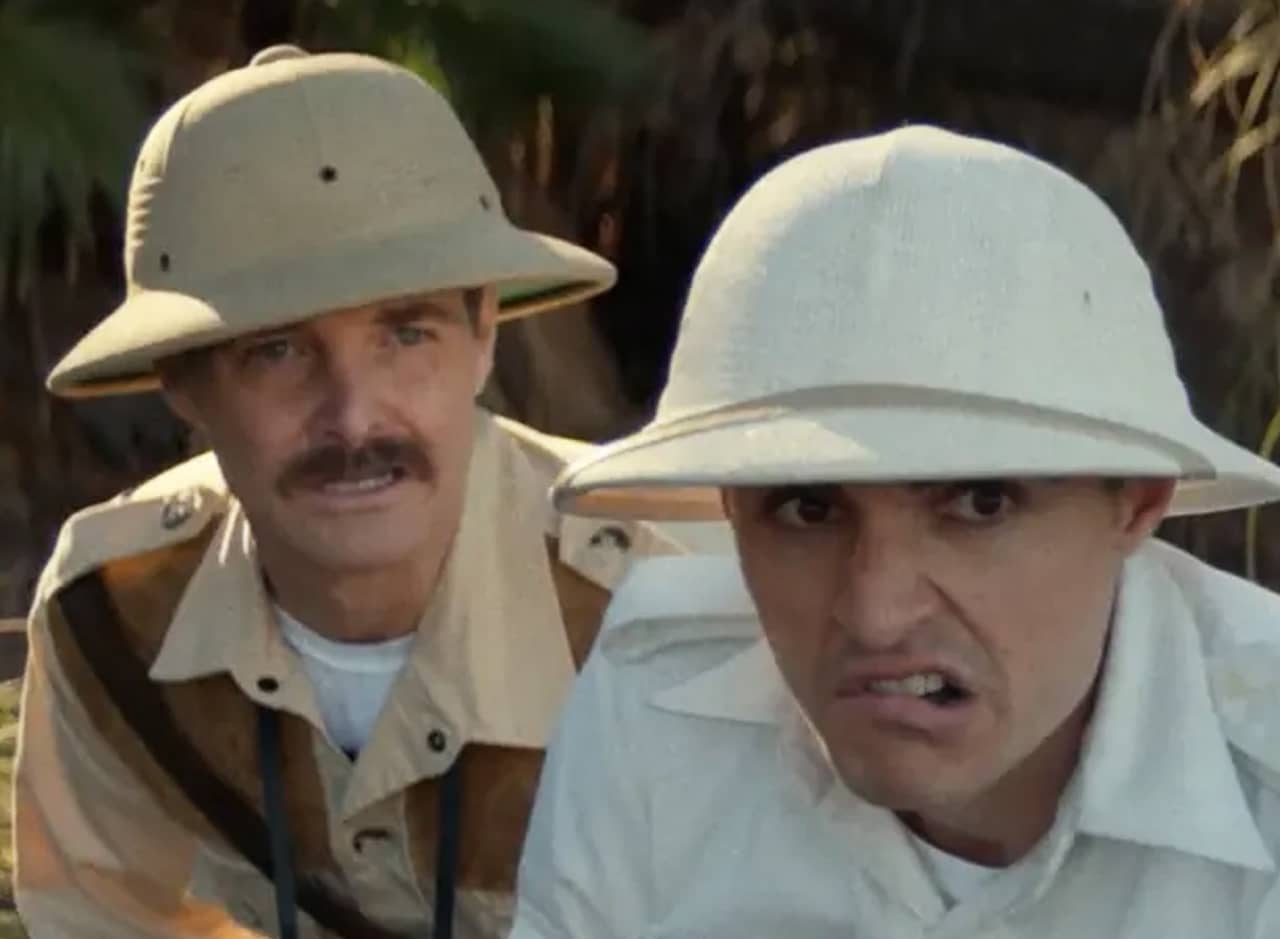 two men in safari garb looking off camera at something intimidating