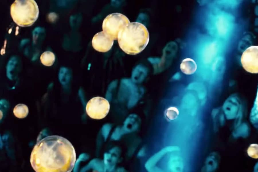glowing liquid drops are rained on a crowd with their mouths open