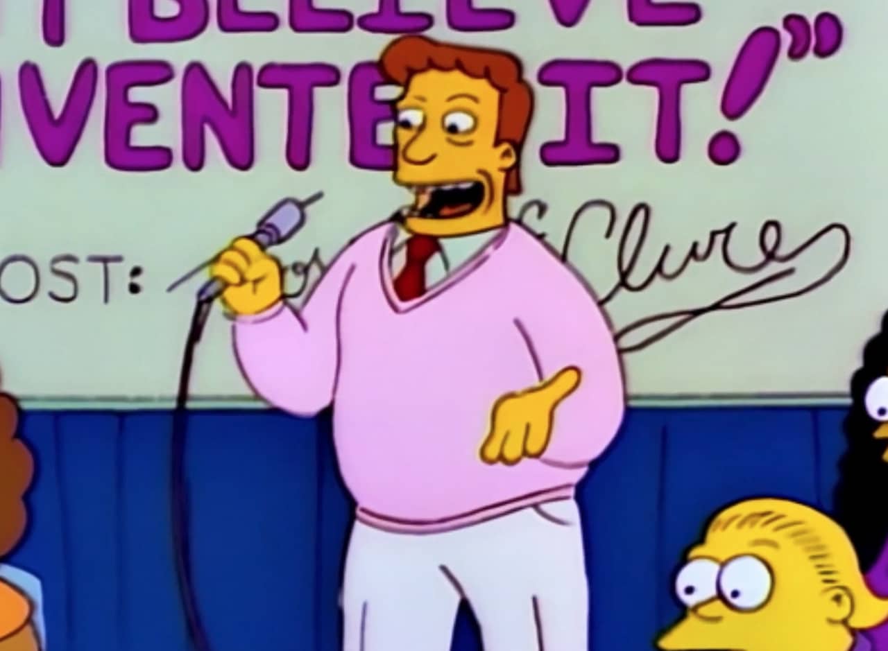 Troy McClure holding a microphone