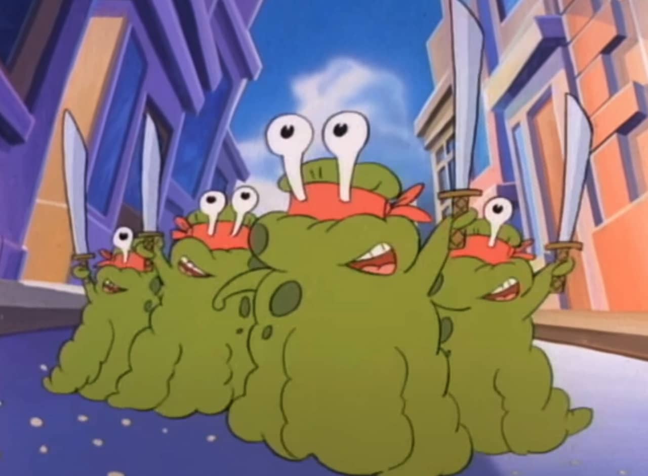 four large green slugs wearing ninja eye masks and holding swords