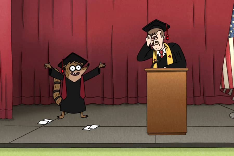 at a graduation, speaker with his face in his hands with embarrassment as a student comes on stage