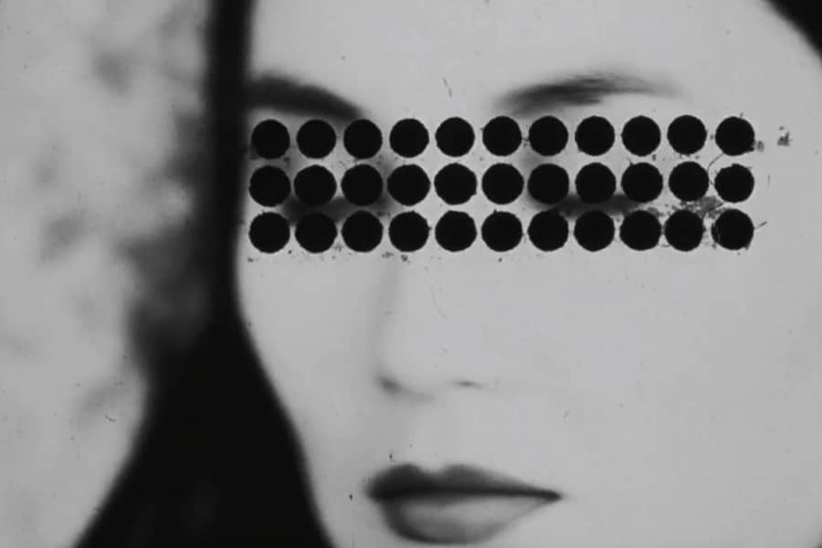 a blurry closeup of the woman with rows of black circles superimposed over her eyes