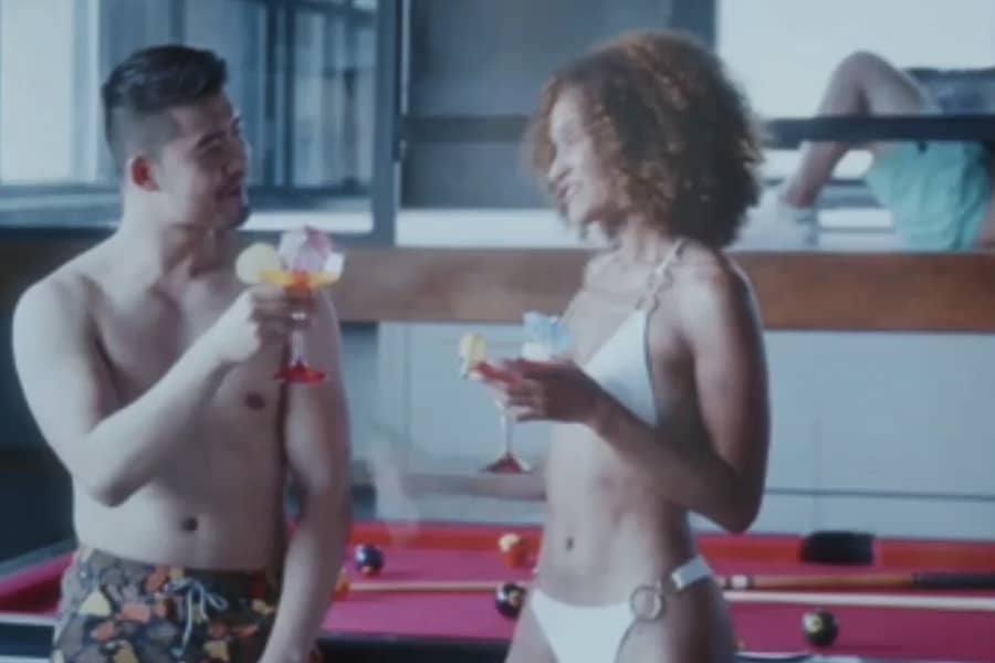 Asian man and Black woman talking in bathing suits