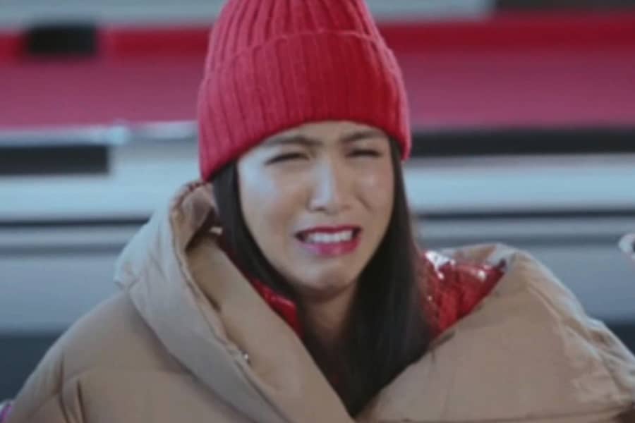 brunette woman bundled up crying