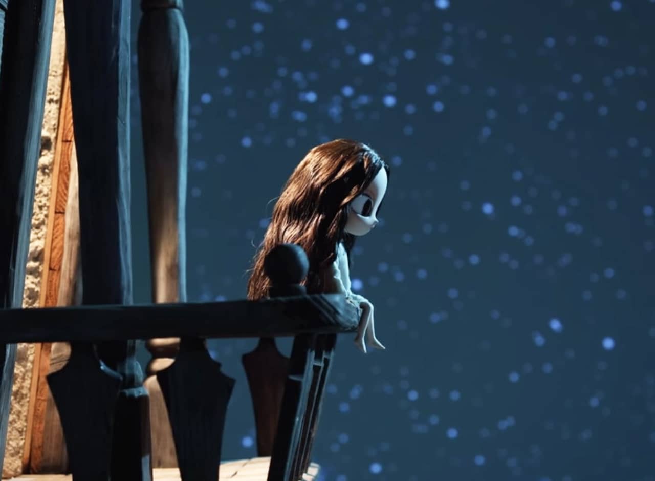 small girl sits on the balcony of a house against a starry sky