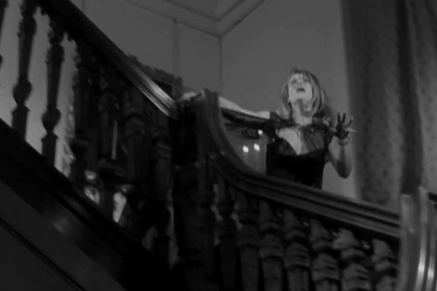 a frightened woman runs down the stairs