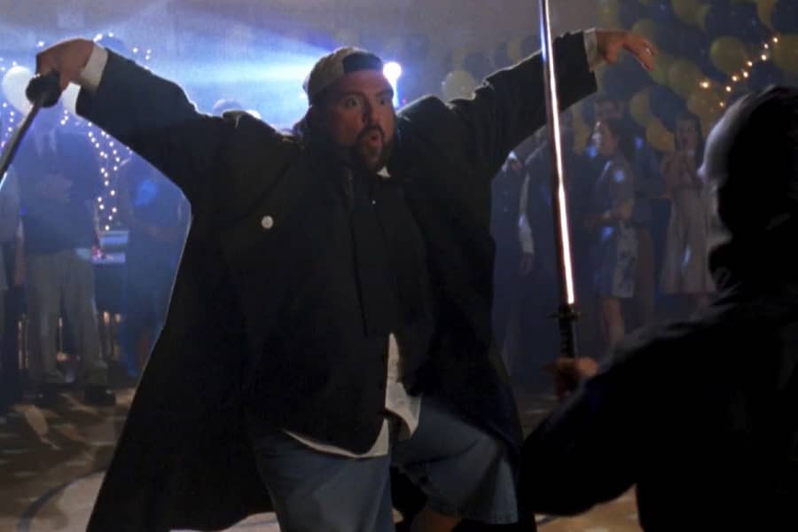 Silent Bob holds a sword and does a praying mantis in front of a ninja