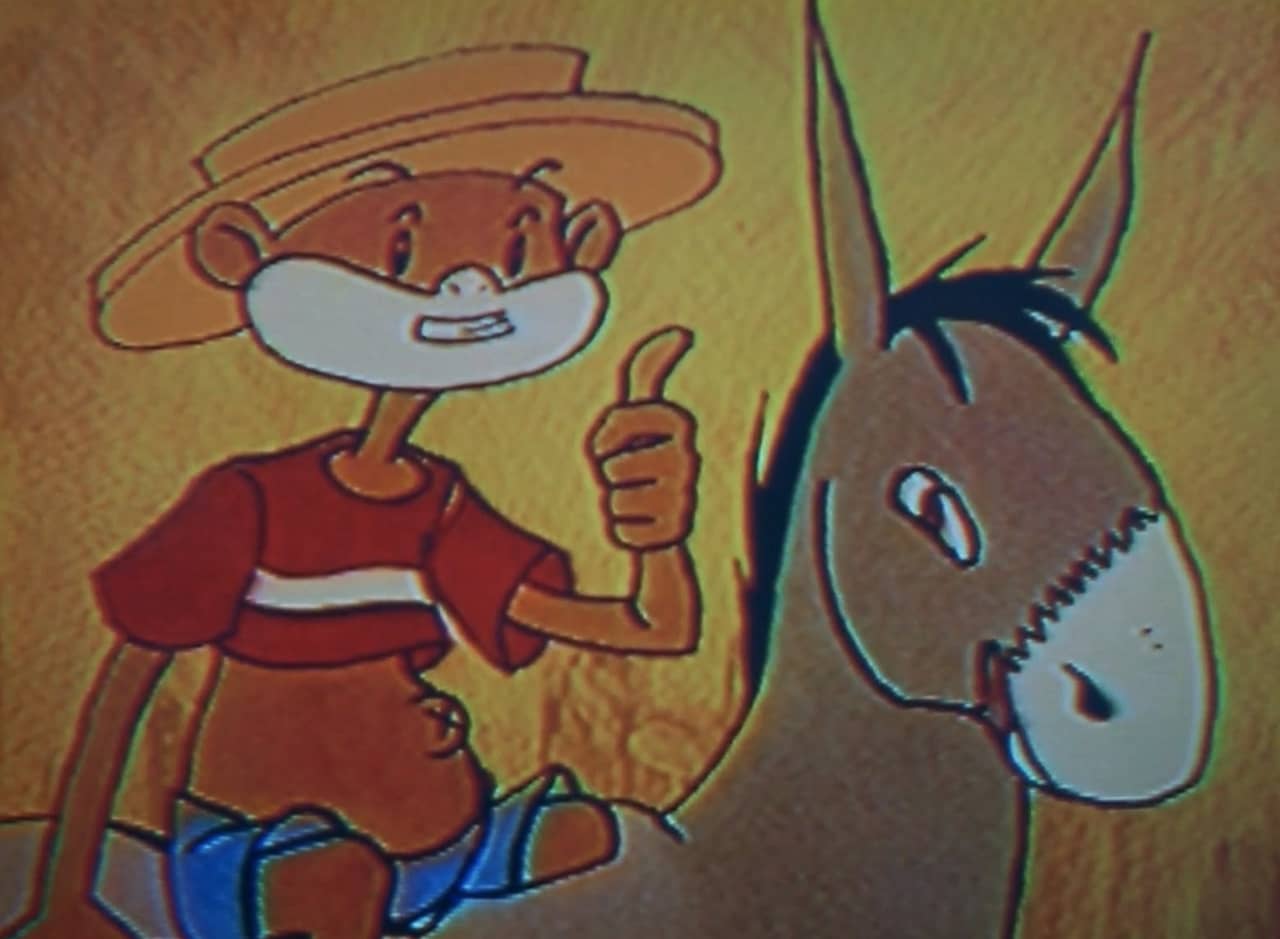 Johnny Chimpo, a monkey in a cutoff tshirt and hat, gives a thumbs up while riding a donkey