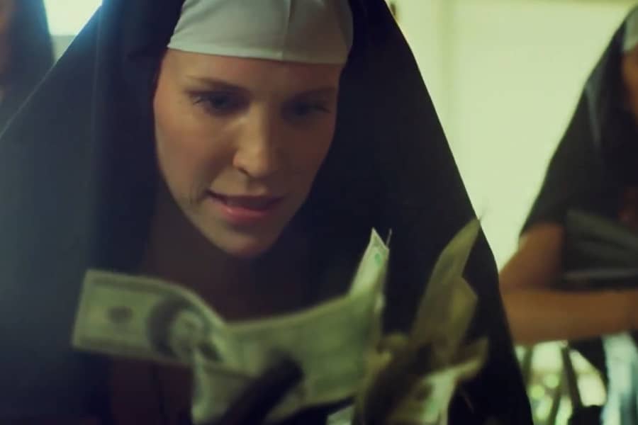 one of the nuns holds a bunch of cash in her hands