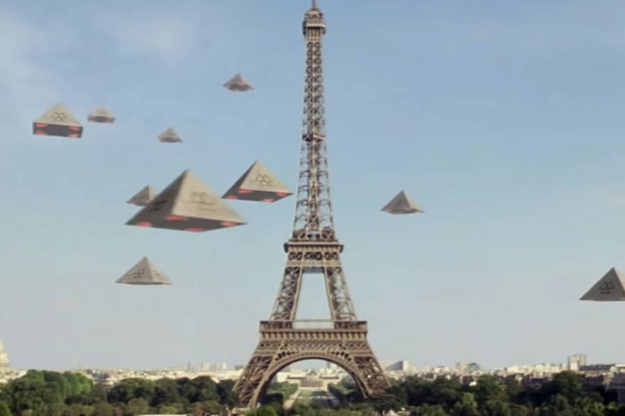 the Eiffel Tower with many pyramids flying around it in the sky