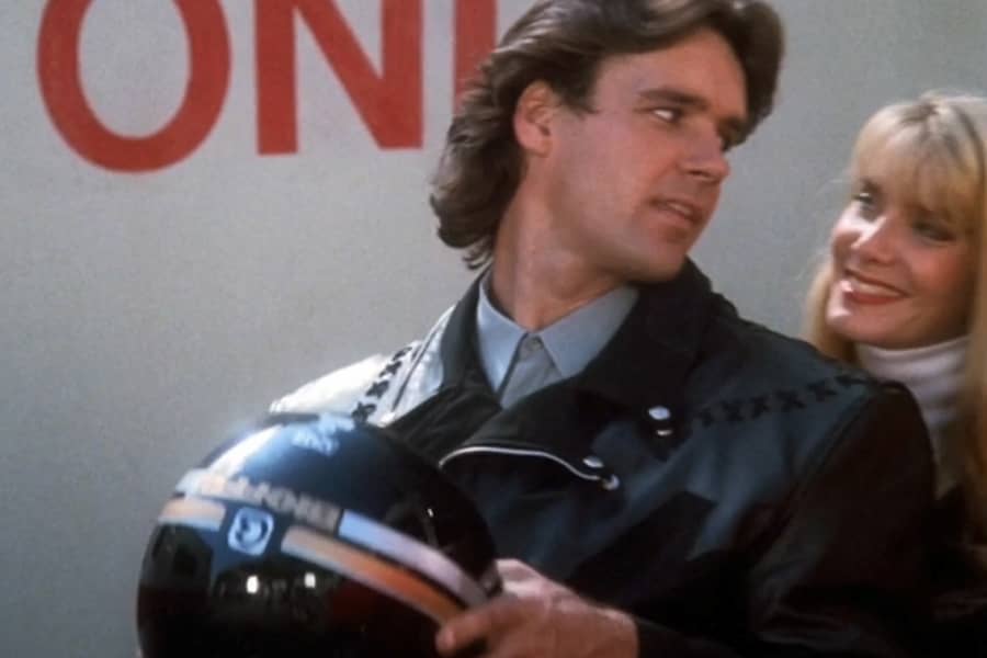 Dr. Chambers getting on a motorcycle with a lady
