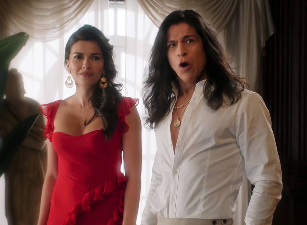 Gabriella in a red dress next to Juan in a white shirt