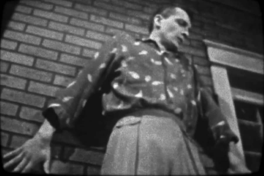 man against the brick of the building looking down