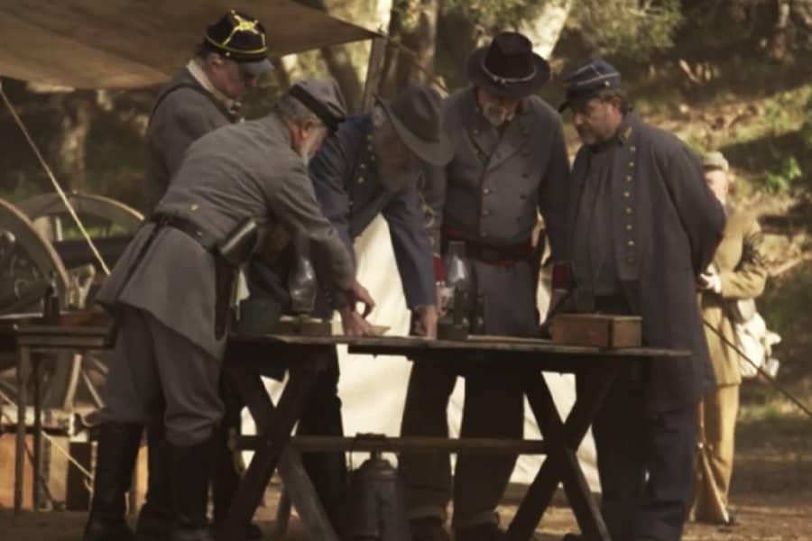 Confederate generals stand around a table