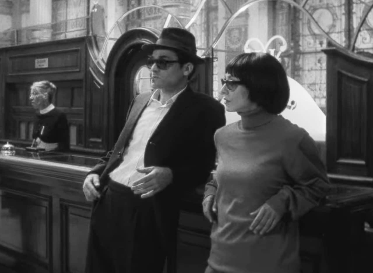 chic man and woman leaning against a counter in a bank
